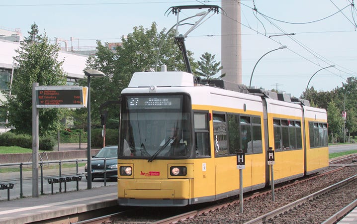 A picture of an orange tram line 27 in Berlin standing at a stop